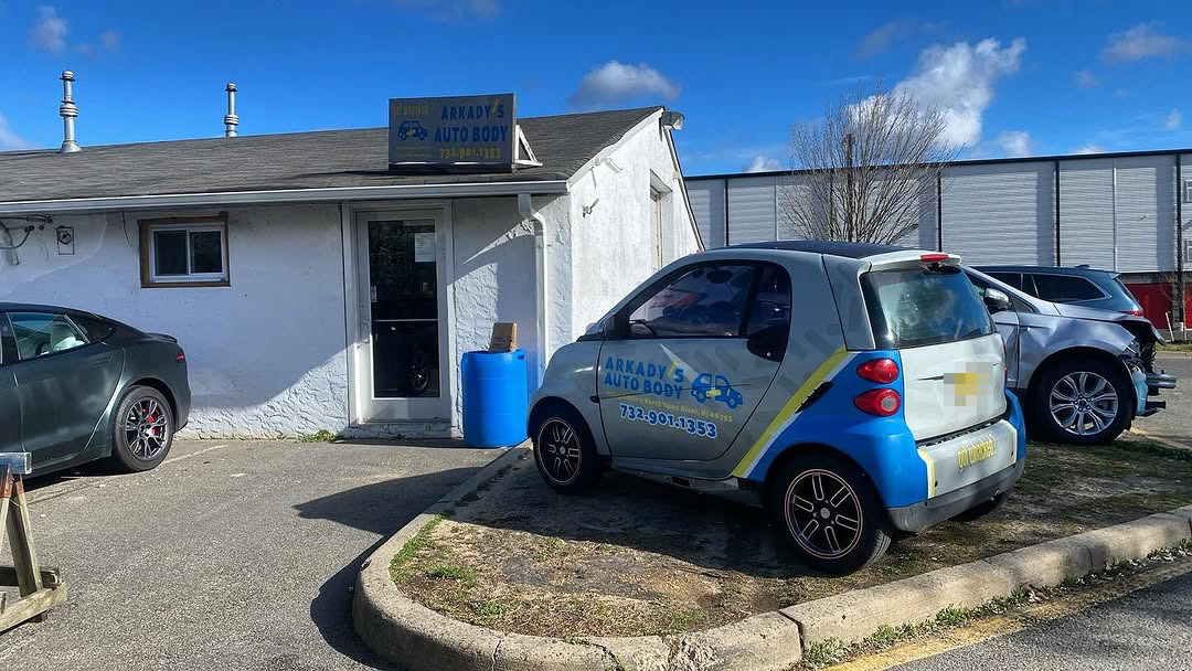 Arkady's shop and sign with the logo-wrapped Smart car parked outside